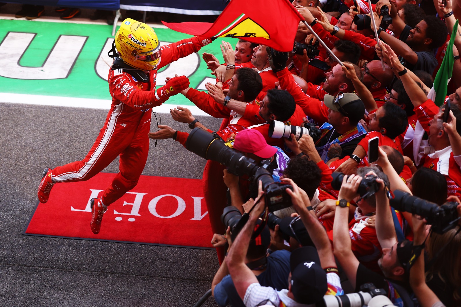 Hamilton comemorando com a equipe na chegada ao podium